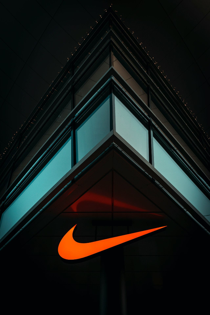 the nike logo is lit up on the side of a building